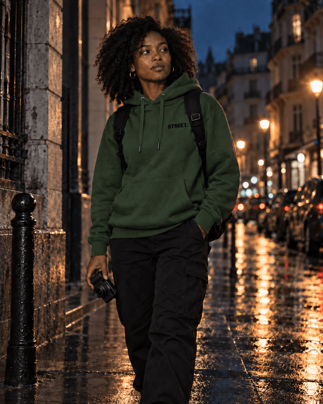 Street photographer wearing the green STREET hoodie on a rainy city street